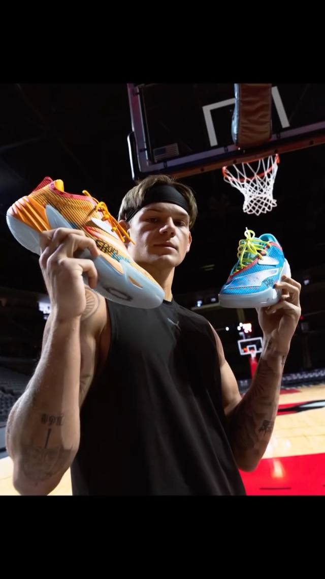 Mac McClung holding up his Puma signature shoes on a basketball court